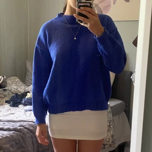 Oversized blå stickad tröja - Säljer en oversized stickad tröja i klarblå färg. Tröjan har lång ärm, ribbade muddar och en högre rund halsringningd. 