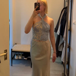 Beige/blå  mönstrad topp från BikBok - Snygg halterneck-topp i ljusblått och beige med paisleymönster. Toppen har knyt i nacken och öppen rygg, vilket ger en trendig och somrig vibe.