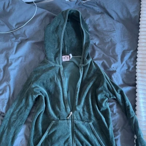 Grön hoodie juicy couture  - Mysig grön hoodie i mjuk frotté med hel dragkedja framtill och två fickor. Tröjan har huva och långa ärmar.litet hål i ena fickan. Det står att det är L men skulle säga den är S/M .Läs bio!💕