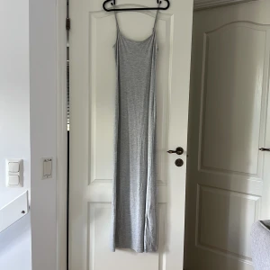 Lång grå maxi klänning Gina Tricot - Lång maxi klänning från Gina tricot. Klänningen har smala axelband som är justerbara, andvänd 1-2 gånger 
