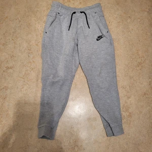 Nike tech byxor  - Grå nike tech byxor i bra skick. För 150kr. Storlek 128-137 cm. Meddela mig om du har en fråga