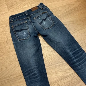 Mörkblå jeans från Nudie - Tjenare! Säljer ett par jeans från Nudie, de är i modellen Grim Tim och har en slim/skinny fit. Storleken är 31/34, jeansen har snygga slitningar och fades. Hör av er vid frågor!
