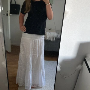 Vit långkjol med smock i midjan - Säljer en vit långkjol med smockad midja och diskret mönster. Kjolen är fin o passar till sommaren! STORLEK 146/150!