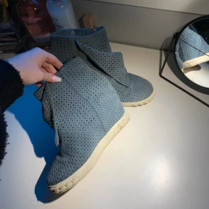 Blåa wedge sneakers från Casadei - Unika turkosa sneakers från Casadei med kilklack och perforerat mocka-tyg. Skorna har dragkedja på sidan och vit platt sula. Perfekt för dig som vill ha en cool och annorlunda look med extra höjd. Snygg design som sticker ut och passar till många outfits.💕