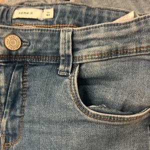 Ljusblå jeans från Name It, stl 164 - Säljer ett par klassiska ljusblå jeans från Name It i storlek 164. Jeansen har fem fickor, normal passform och raka ben. dem är mid- high waist så är därför lite korta u benen💗💗