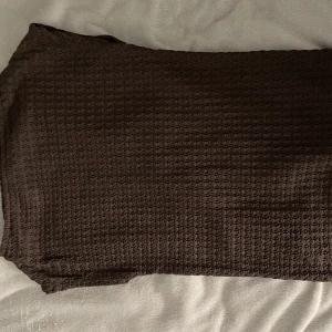 Brun topp - Brun topp med vågigt mönster i tyget. Perfekt för dig som gillar en enkel men ändå trendig look. 