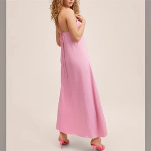 Ljusrosa långklänning med smala band - Superfin ljusrosa långklänning från Mango i slinkigt material. Klänningen har smala axelband, v-ringning och öppen rygg med knyt.