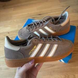 Adidas Spezial sneakers i beige mocka -  Snygga Adidas Spezial J sneakers i beige mocka med klassiska vita ränder och guldtext. Stl 36 2/3 Nya med prislapp. Skickas i original lådan som skorna kom i.