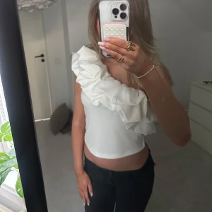 Vit one shoulder topp med volang - Säljer denna super fina one shoulder toppen för att den inte används. Nyskick❣️❣️