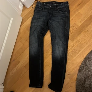 Mörkblå jeans från Jack & Jones - Snygga mörkblå jeans från Jack & Jones med en slim passform. Perfekta för en stilren look. De har en klassisk design med fem fickor och knappgylf. Storlek 30/32