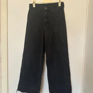 Svarta jeans - Snygga svarta jeans med hög midja. Byxorna har en vid passform och är tillverkade i denim. 