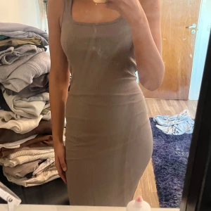 Beige ribbad klänning från Lager157 - Säljer en stilren beige ribbad klänning med tight passform. Klänningen är ärmlös och har en enkel design som passar perfekt för olika tillfällen. Perfekt för dig som gillar en minimalistisk stil.