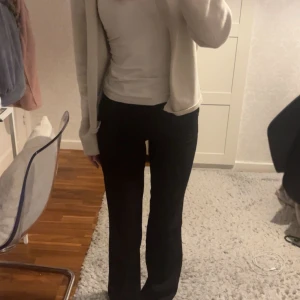 Svarta kostymbyxor - Snygga svarta kostymbyxor med hög midja och bootcut-stil. Perfekta för både vardag eller finare tillfällen. Nypris 499kr