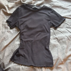 Svart ribbad t-shirt - Svart ribbad t-shirt med vågiga ärmar. Passar till typ allt💕