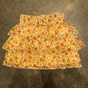 Gul volangkjol - Sommarkjol minikjol perfekt för sommaren. Sött mönster med små blommor på. Mycket bra skick. Storleken är barn 170cm men det motsvarar S