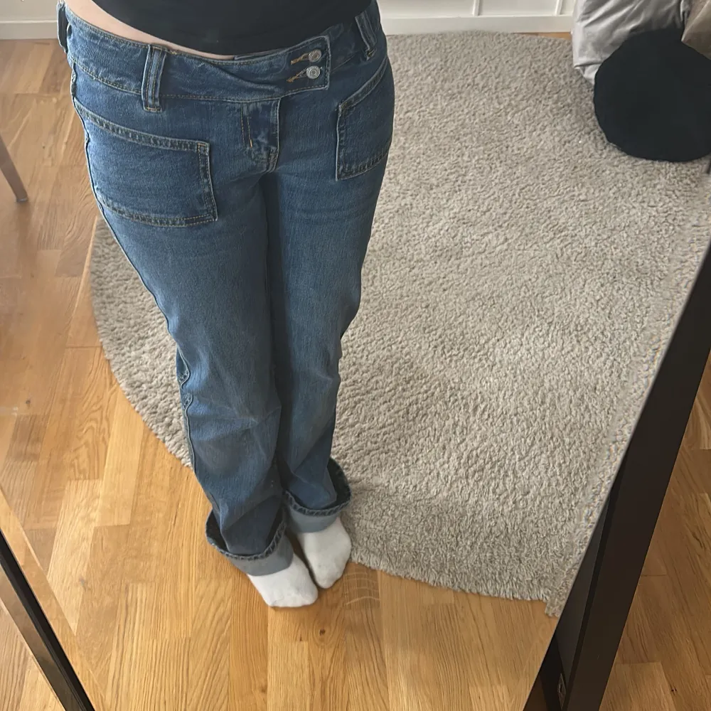 Snygga blå jeans med dubbla knappar framtill och en klassisk femficksdesign. De har en rak passform och är perfekta för en avslappnad stil. Jeansen har en medelhög midja och är tillverkade i ett slitstarkt denimtyg.. Farkut & Housut.