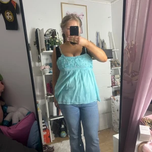 Linne  - Säljer en söt turkos ärmlös topp med spetsdetaljer på framsidan. Storlek XL men liten i storleken, jag brukar ha L i toppar och denna går inte att knäppa igen för mig💓