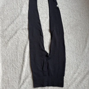 Svarta tights från Lager 157 - Säljer ett par svarta seamless tights från Lager 157 i storlek XS/S. De är designade för att sitta bekvämt och har en ribbad kant vid anklarna. Perfekta för träning.