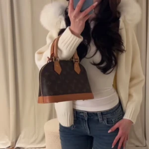 Vit cardigan jacka med pälshuva - Snygg vit cardigan jacka med en fluffig pälshuva. Jackan har långa ärmar och ribbade muddar. Perfekt för kyligare dagar när du vill hålla stilen.