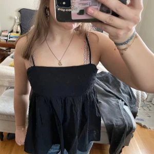 Svart linnetopp  - Säljer en svart linnetopp med tunna svarta axelband och en rynkad midja. Toppen har en luftig passform och är perfekt för varma dagar. Snygg att styla med jeans eller kjol. Står ingen strlk men passar fint pp mig som har S❣️❣️