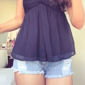 Ljusblå jeansshorts med fransar - Säljer ett par ljusblå jeansshorts med slitna detaljer och fransig kant. Klassisk femficksmodell med knapp och dragkedja framtill. Perfekta för varma dagar!