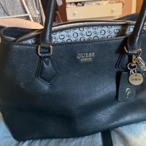 Svart handväska från Guess - säljer min jättefina guess väska, nypris är 1300, kp för fler bilder ❤️