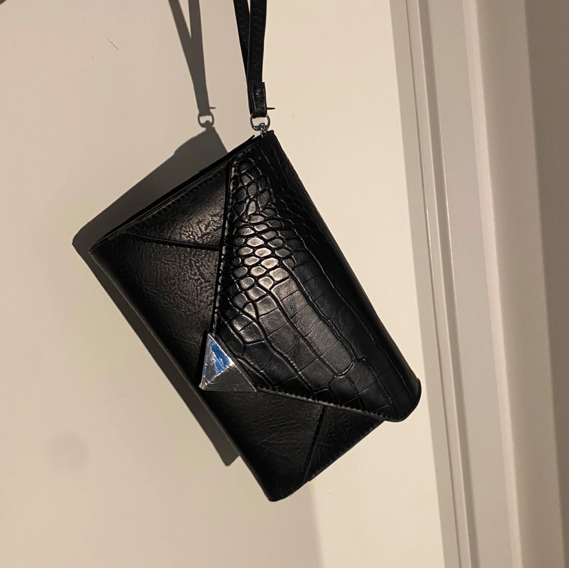 Svart axelväska med kedja och krokopräglat mönster