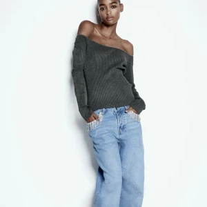 Grå ribbad offshoulder-tröja - Snygg grå ribbad tröja med offshoulder-design och med nitar. Helt ny och aldrig använd!