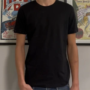 Valentino tshirt - Säljer denna svarta Valentino T-shirt med nitar på ärmarna och vid midjan! Tröjan är i perfekt skick förutom att en nit är borta på vänsterarmen, detta märks knappt dock. Size L passar M. Modellen på bilden är 182cm lång. Skriv vid funderingar!