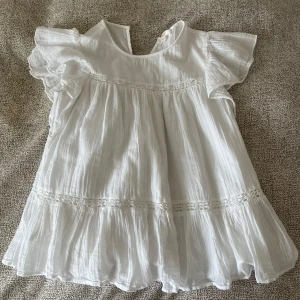 Vit blus med volang från Gina Tricot - Superfin vit blus från Gina Tricot med volangdetaljer och korta ärmar. Blusen har en luftig och lätt struktur med spetsinslag och rund halsringning. Tyvärr bara använd 1 gång och sedan lämnad i garderoben 