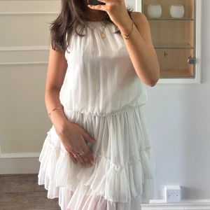 Studentklänning / vit klänning  - Jättefin vit klänning med volanger, perfekt som studentklänning, aldrig använd, nypris 700kr, passar xs/s