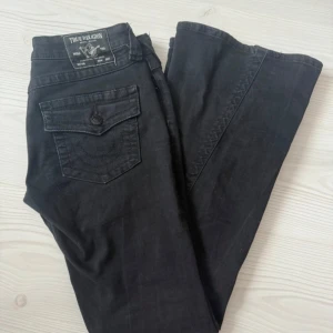 Svarta True Religion Joey jeans - Säljer svarta True Religion jeans, modell joey. Strl 26. Använda en gång men är tyvärr för stora för mig. Helt slutsålda, nypris 1300kr