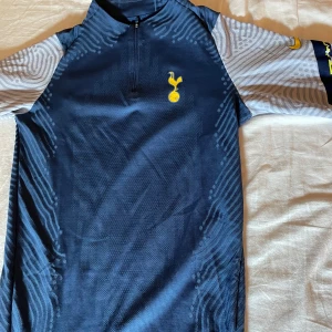 Tottenham tränings tröja  - Säljer en blå och grå träningströja från Nike med dragkedja och Tottenham på bröstet. Köpt i Tottenham hotspur shoppen i london. Fantastiskt skick och otroligt snygg 10/10