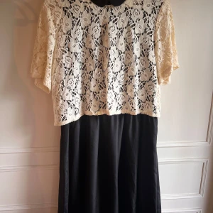 Svart och vit klänning med spets från Vero Moda - Säljer en fin svart klänning från Vero Moda med tillhörande spetsöverdel. Oanvänd.
