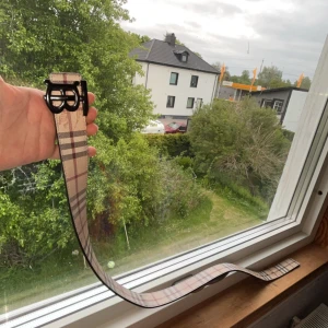  burberry bälte med två sidor! - Säljer ett rutig bälte med svart spänne. Bältet har klassiskt beige, svart och rött rutmönster och är tillverkat i ett material som liknar jeans. Passar perfekt till jeans eller andra byxor för en snygg detalj.