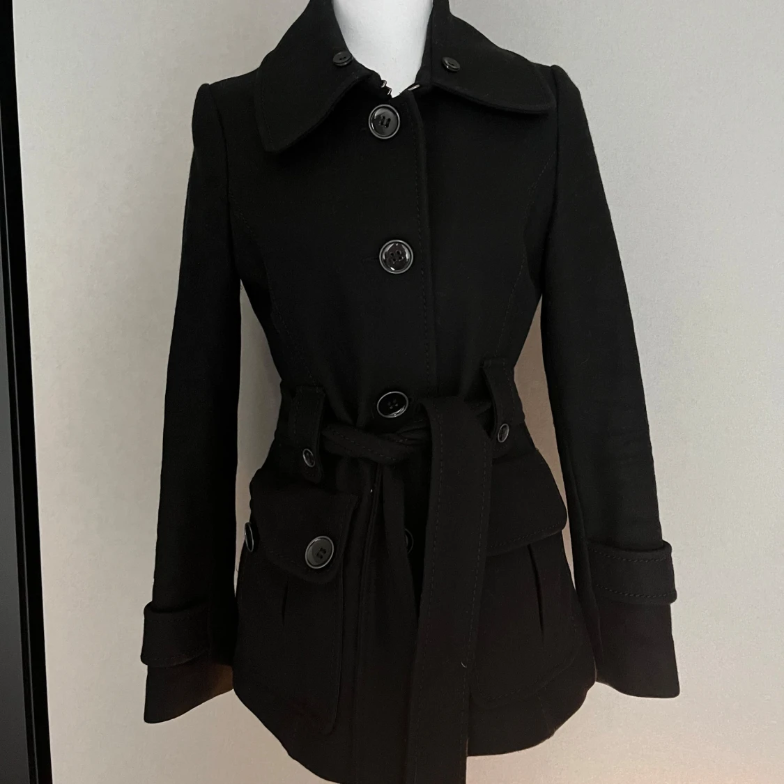 Svart kappa med bälte och stora knappar