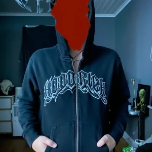 Svart hoodie med tryck från HOODRICH  - Säljer min svarta äkta hoodrich tröja för har bytt klädstil, fint skick, inga skador, knappt använt. I storlek S fast funkar på M. 