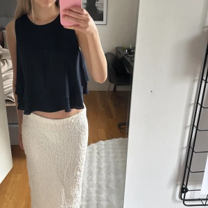 Mörkblå volangtopp från Zara Basic - Säljer en mörkblå volangtopp från Zara Basic. Toppen är ärmlös och har en lös passform med dubbla lager tyg som ger en snygg volangeffekt. Perfekt att styla till både kjol och byxor.