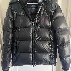 Polo Ralph lauren puffer jacket - Tja, säljer nu den här svarta polo Ralph lauren jackan då den är lite för stor så den har inte kommit till nån användning,  Den är i ny skick, inga skador. Hör av er vid frågor! Byte mot en liknade jacka i strl S (Ny pris 6000)