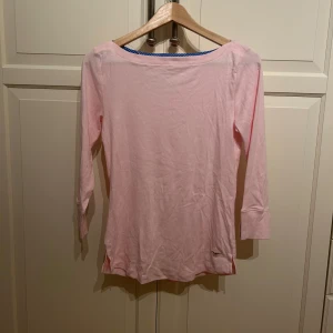 Ljusrosa långärmad topp från Hampton Republic - Säljer en ljusrosa långärmad topp från Hampton Republic. Tröjan har en enkel design med rund halsringning och diskret logga nertill. Tillverkad i mjuk bomulls material. Är i strl S