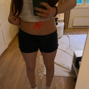 Marinblåa shorts från Brandy Melville - Marinblåa shorts från Brandy Melville i mjuk bomull. De har en enkel design med väldigt låg midja, kort passform och är väldigt stretchiga. Ser svarta ut men är mörk mörkblåa. Är 158 men passar perfekt som vuxenstorlek också. Perfekta för varma dagar eller för att stanna hemma eller hänga med kompisar! Säljer för att de inte kommer till användning. Jag har inte använt de någon gång, bara testat💘så sååååå snygga rekommenderar verkligen!! 