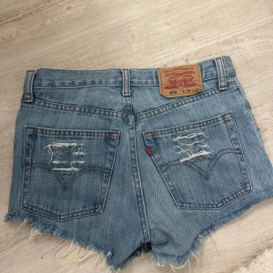 Blå slitna jeansshorts från Levi's - Säljer ett par blå jeansshorts från Levi's med lite slitningar. Tycker dom är jättefina. Men köpte dom i för små storlek, så kan inte stänga dom de är derför jag säljer dem. De står att dom är i size 29.😊