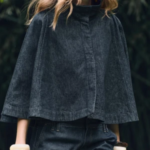 Svart jeanscape med hög krage och shorts - Säljer denna svarta cape i jeansmaterial med tillhörande shorts i denim💗 aldrig använt! Slutsålt