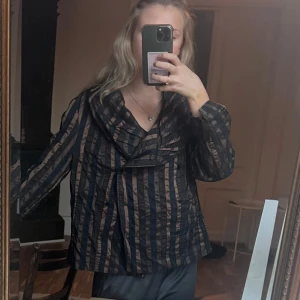 Svart och brun randig jacka med krage - Säljer en svart och brun jacka med breda ränder och stor, draperad krage. 😍