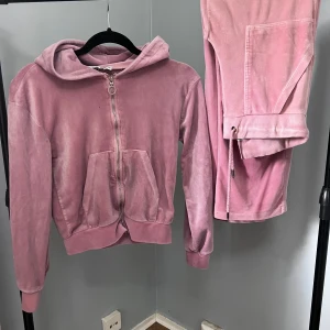 Rosa velourset från Lager157 - Säljer ett klassiskt rosa velourset från Lager 157 i mjuk velour med dragkedja och huva. Tröjan har långa ärmar, fickor framtill och ribbade muddar. Perfekt för en avslappnad och trendig look.