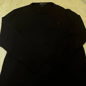 Marinblå polo ralph lauren tröja - Säljer en tunn stickad tröja från polo ralph lauren. Den är marinblå även om den ser svart ut på bilden. Tyvärr är den något krympt i tvätten så den är mer som en M än en XL. Inga andra defekter förekommer. 