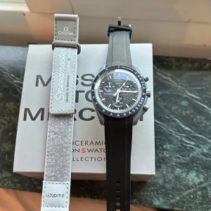 Omega x Swatch Speedmaster MoonSwatch - Säljer en svart Omega x Swatch Speedmaster MoonSwatch med svart urtavla och svart armband. Klockan har kronograf och tydliga vita markeringar på urtavlan. Levereras i originalförpackning med tillbehör.