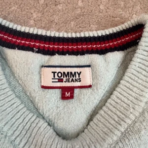 Ljusblå tröja från Tommy Jeans - Säljer en ljusblå supermysig stickad tröja från Tommy Jeans i storlek M. .