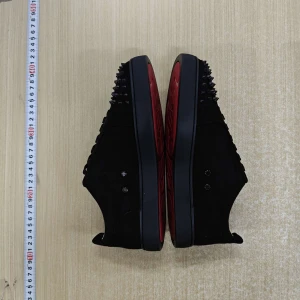 Svarta sneakers med nitar från Christian Louboutin - Säljer ett par svarta sneakers från Christian Louboutin med svarta nitar på tån och klassisk röd sula. Skorna är i mocka och har snörning framtill. Snygg och edgy design som sticker ut.