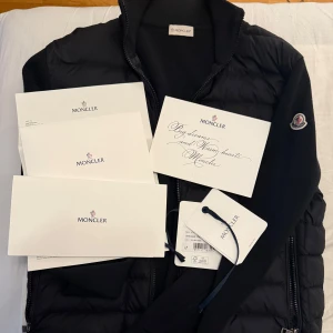 Moncler Tricot Cardigan (M) - Säljer min välvårdade äkta Moncler Tricot Cardigan, då jag har tröttnat på den. Kvitton, tags och allting följs med. Storlek: M. Tar endast swish och kan även fraktas med PostNord spårbar frakt. Kör ej via Plick köparskydd.